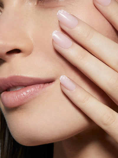 Soft pink manicure with white flowers at tips of all nails in round shape,