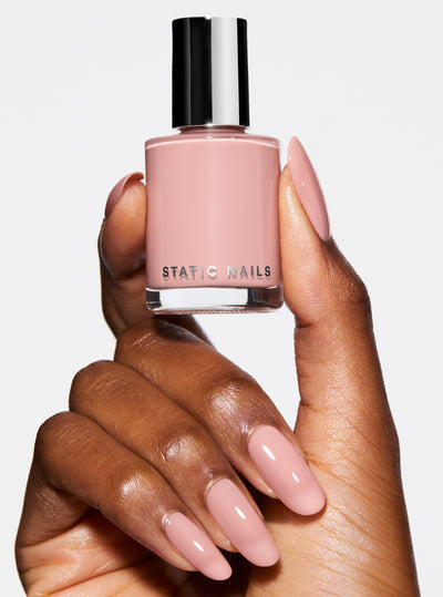 BARELY THERE 5-IN-1 RAPID GROWTH NAIL TREATMENTHand holding a bottle of pink nail polish with &