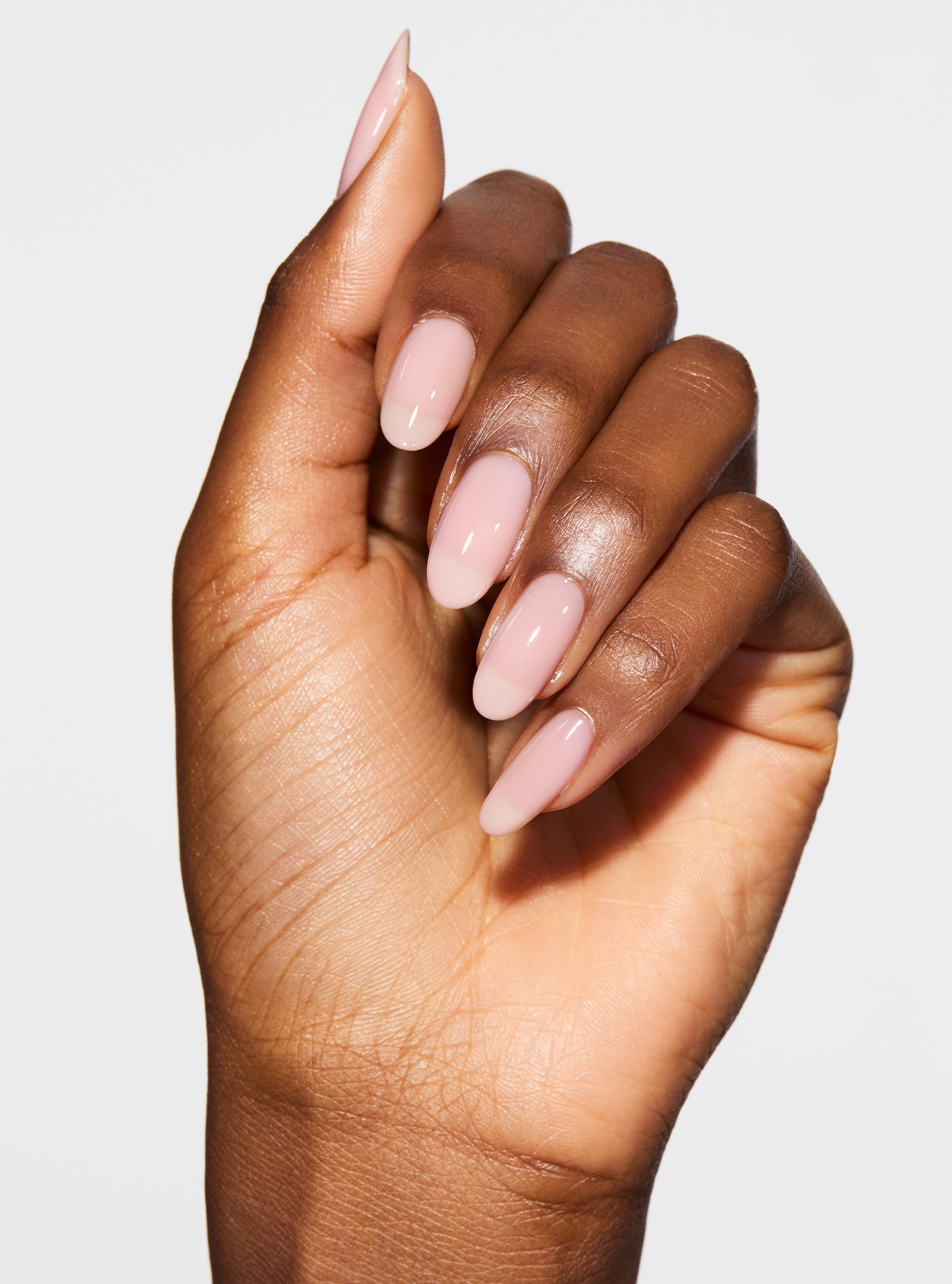 Hand with pink nail polish on a pink background
