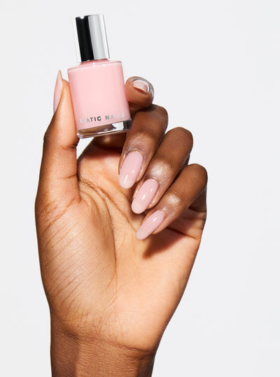 SIGNATURE PINK 5-IN-1 RAPID GROWTH NAIL TREATMENTHand with pink nail polish on a pink background