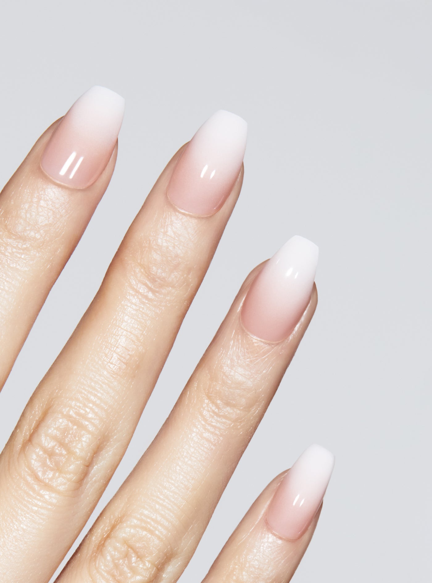 Ombre light pink to white manicure in coffin shape,