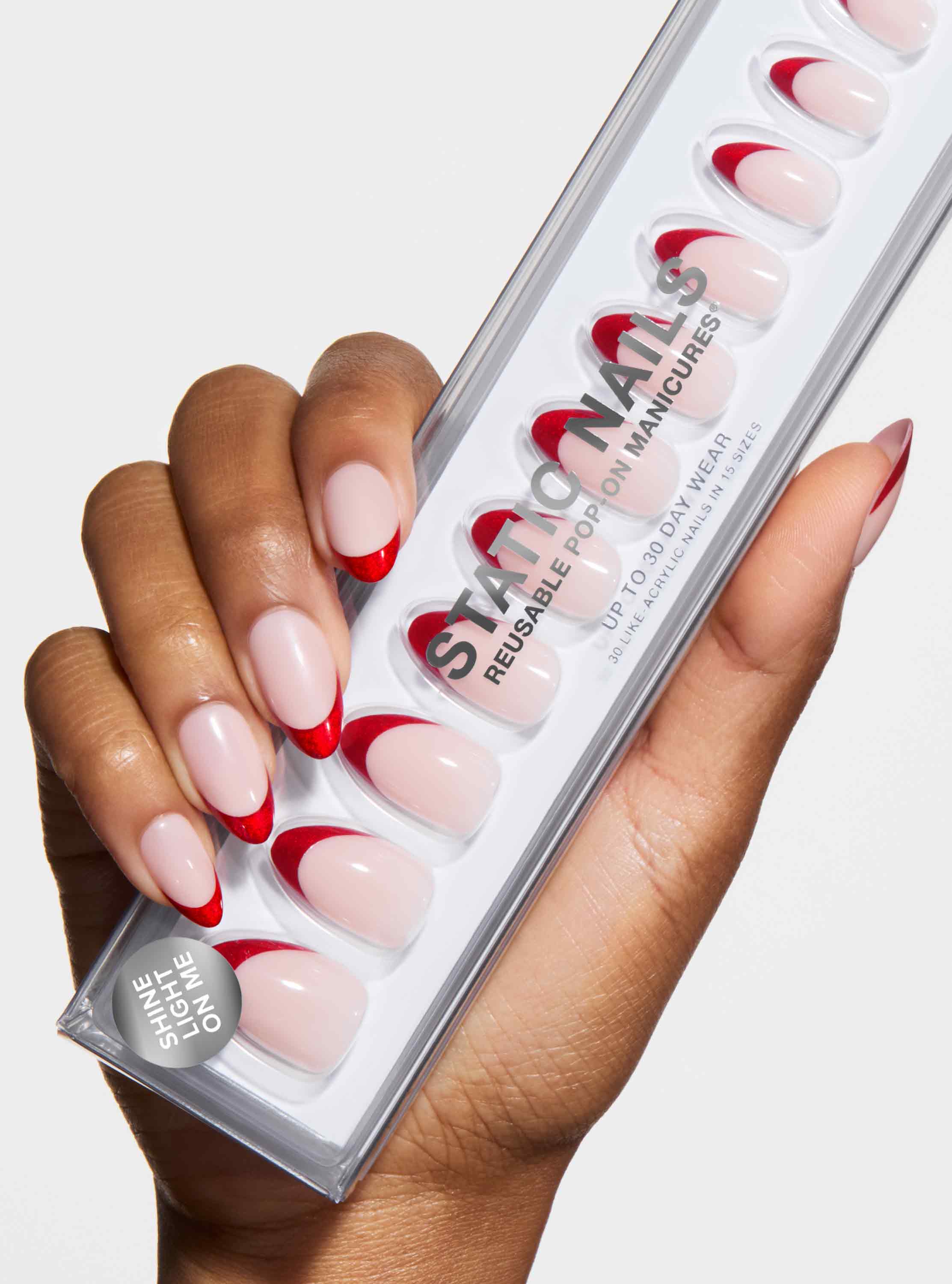 hand holding box of nude nails with red velvet french tips