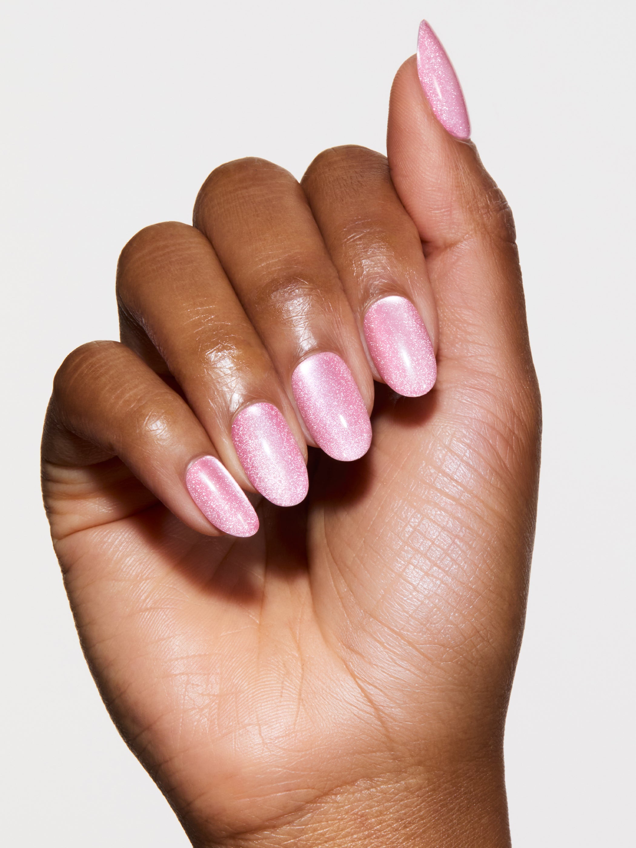 Hand with pink nail polish on a light background