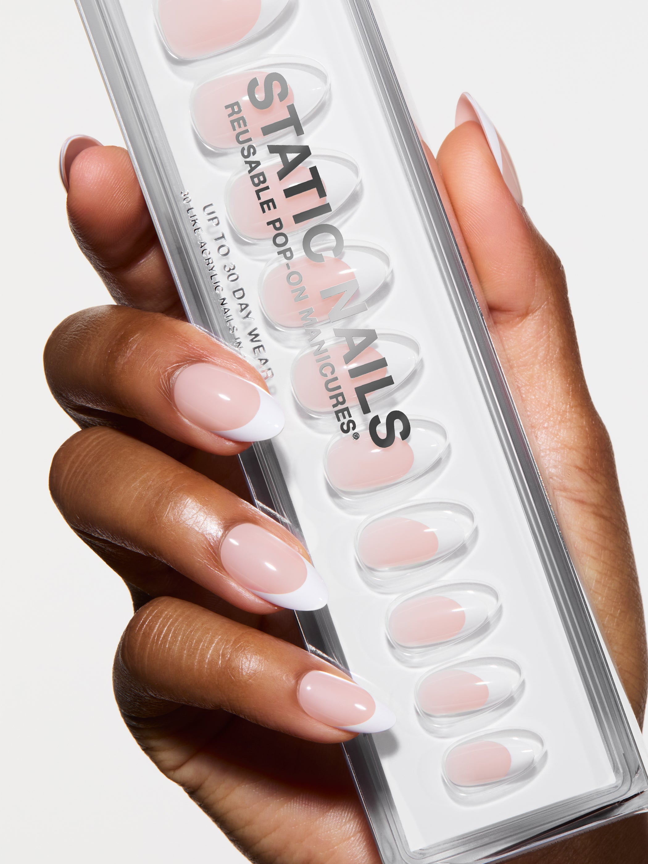 Hand holding a pack of false nails with &