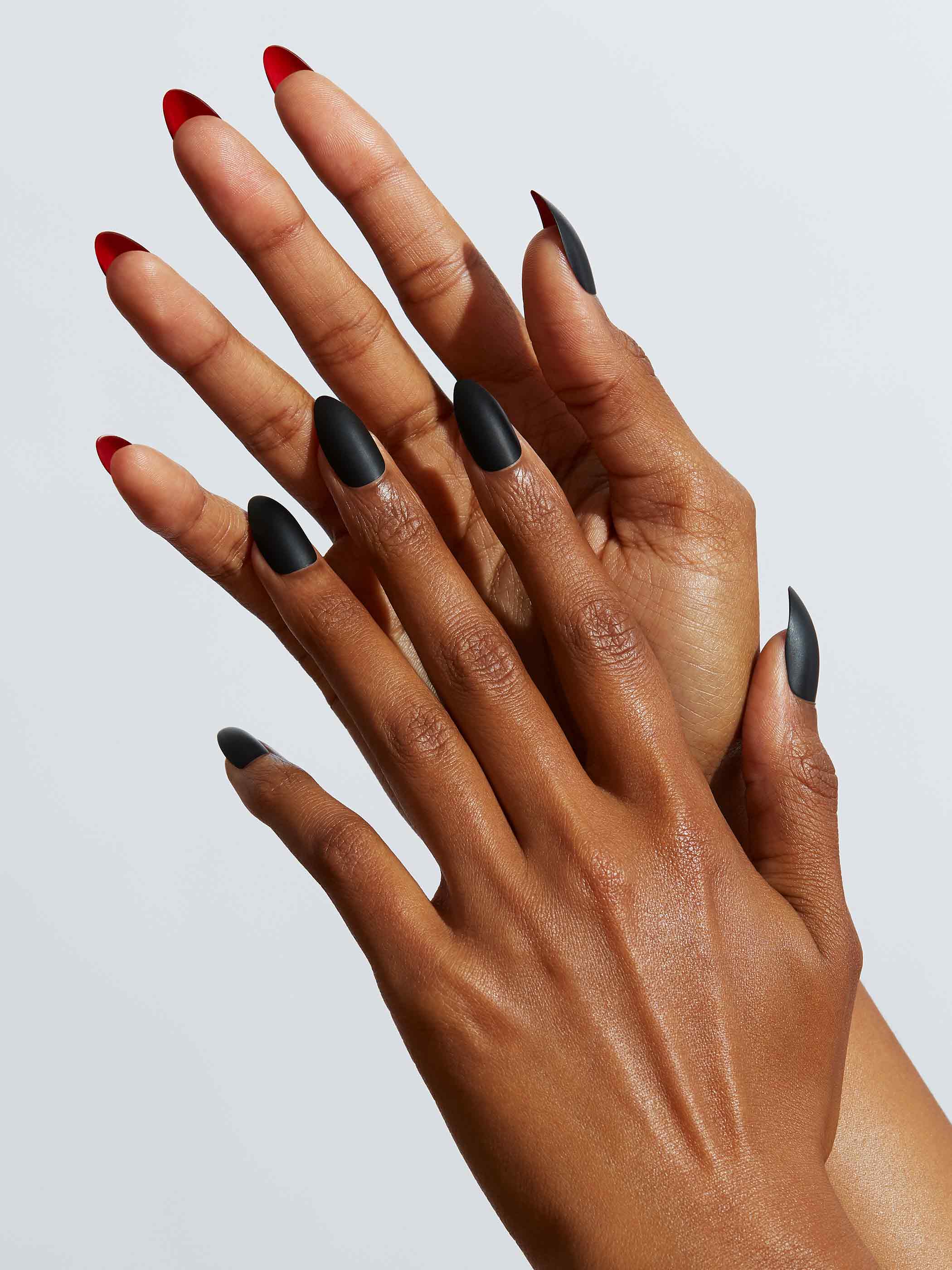 Matte black manicure with red under nails in almond shape,